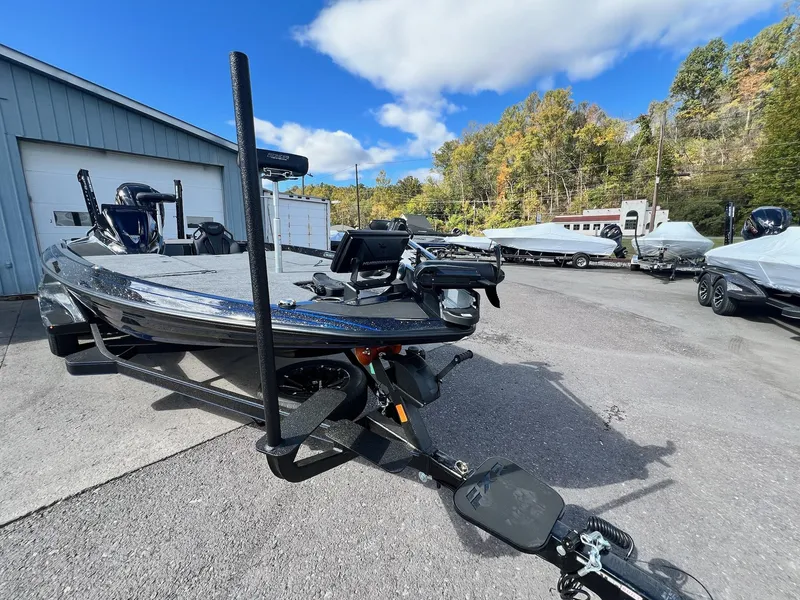 Slide: The Image of 2025 Skeeter FXR21 LE boat parked outdoors on a sunny day. - 12