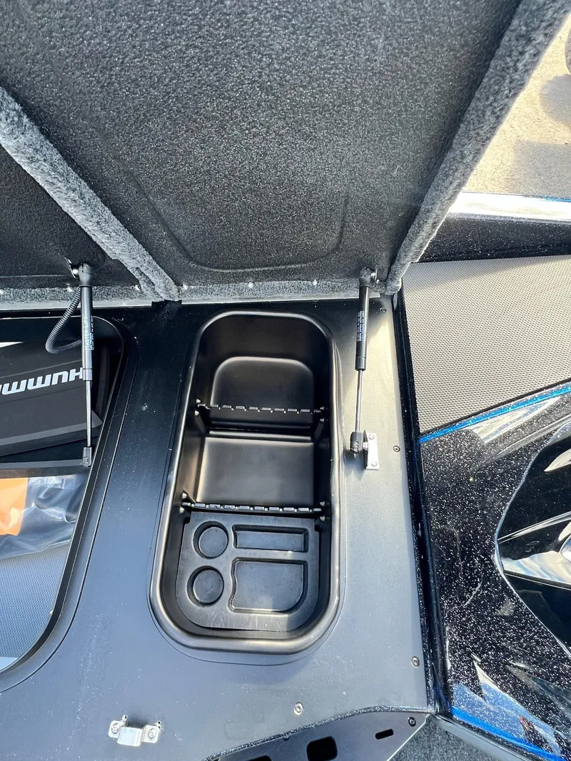 Slide: The Image of 2025 Skeeter FXR21 LE boat storage compartment with open lid and organized interior. - 14