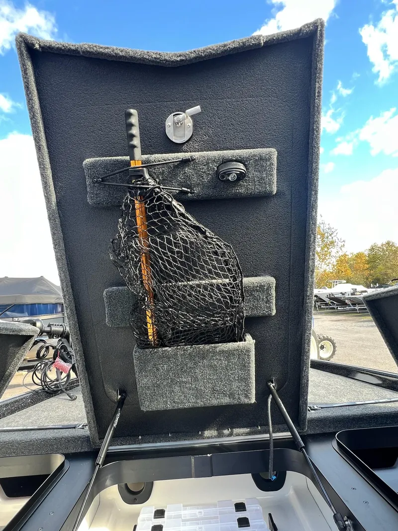 Slide: The Image of 2025 Skeeter FXR21 LE boat storage compartment with fishing net and clear sky background. - 20