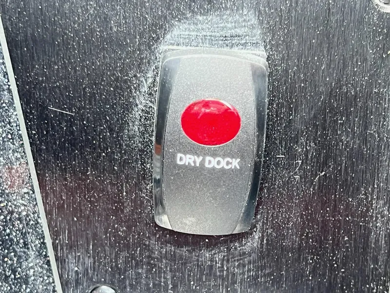 Slide: The Image of Red "Dry Dock" button on 2025 Skeeter FXR21 LE boat dashboard. - 34