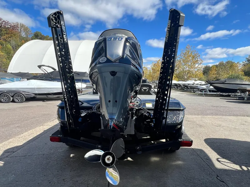 Slide: The Image of 2025 Skeeter FXR21 LE boat with powerful outboard motor, parked outdoors under blue sky. - 37
