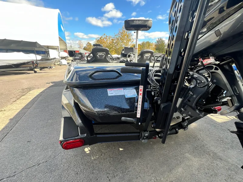 Slide: The Image of 2025 Skeeter FXR21 LE boat rear view, parked outdoors under a clear sky. - 38