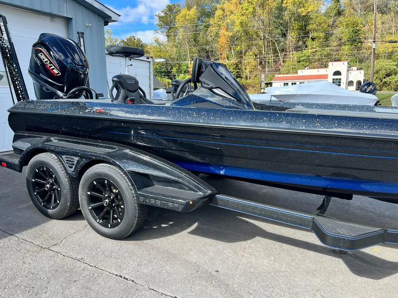 Slide: The Image of 2025 Skeeter FXR21 LE boat with dual axle trailer, parked outdoors. - 42