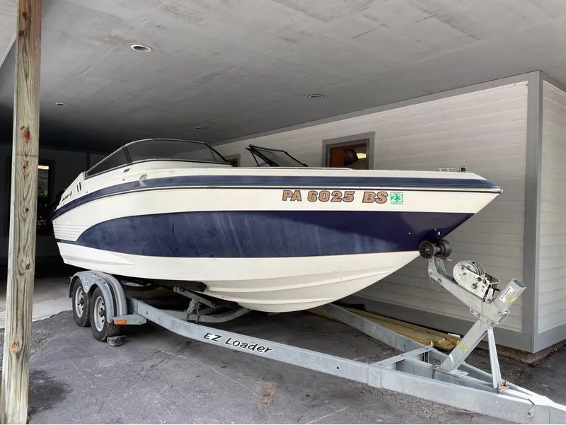 Slide: The Image of 1996 Celebrity 220 boat on trailer under shelter. - 1