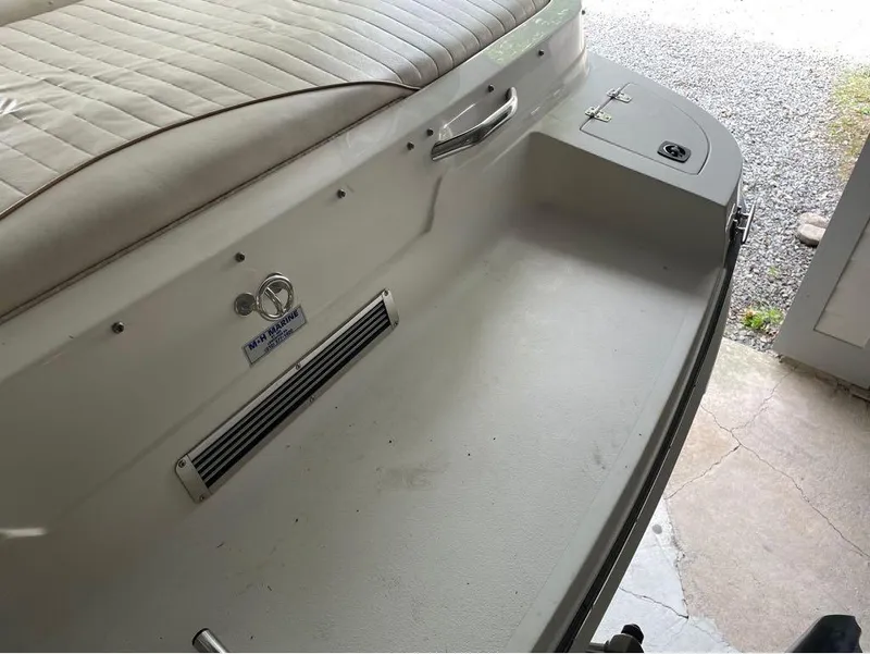 Slide: The Image of Interior of a 1996 Celebrity 220 boat with white seating and storage compartment. - 13