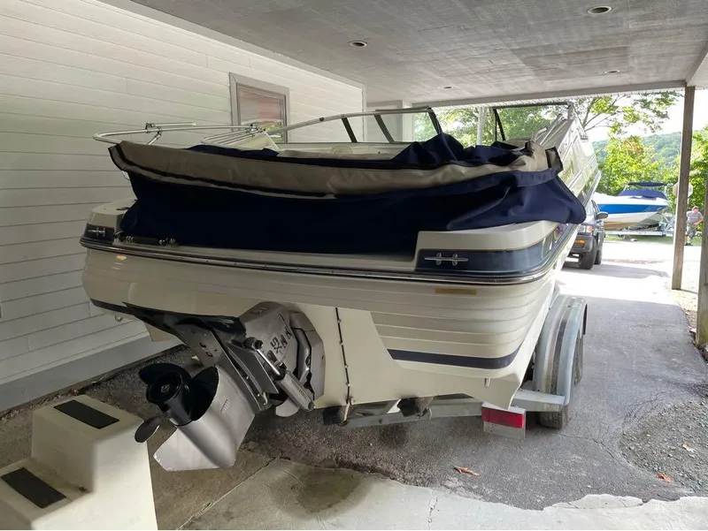 Slide: The Image of 1996 Celebrity 220 boat on trailer under a carport. - 2