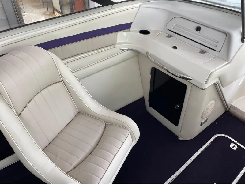 Slide: The Image of Interior of a 1996 Celebrity 220 boat with white seating and dashboard. - 6