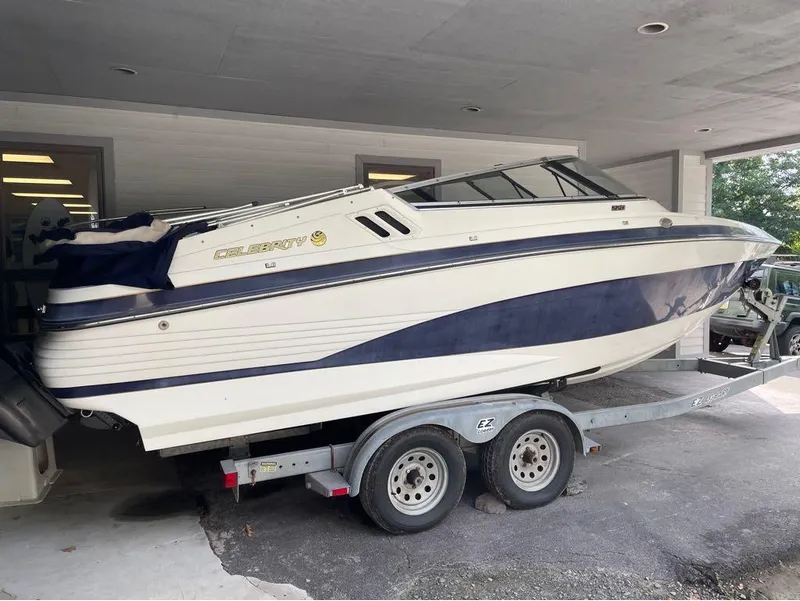 Slide: The Image of 1996 Celebrity 220 boat on trailer, parked under a covered area. - 8