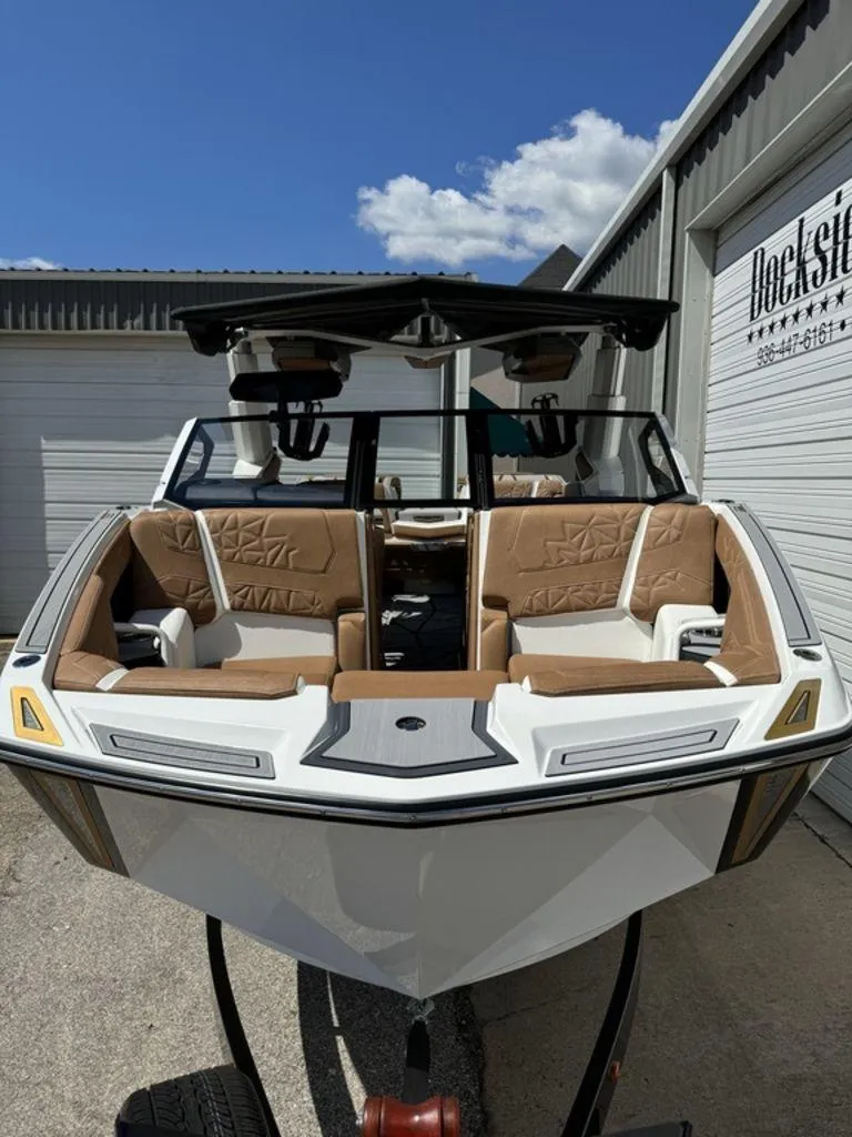 Slide: The Image of 2025 Nautique PARAGON 23 boat with luxurious tan seating, dockside view. - 2