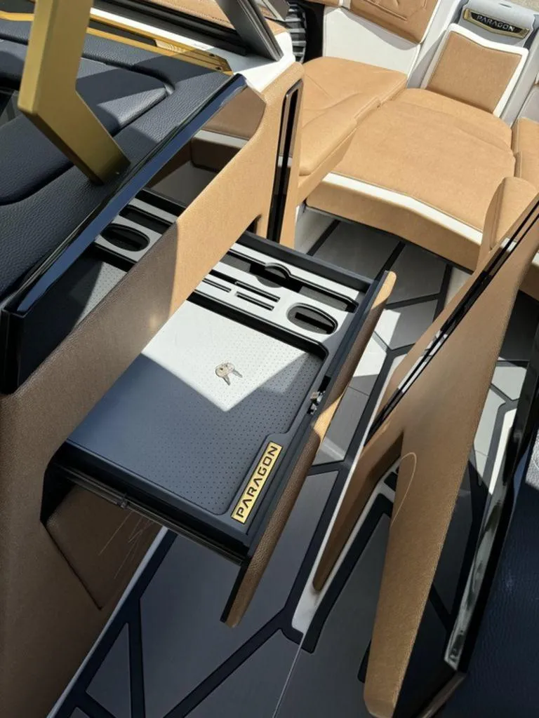 Slide: The Image of 2025 Nautique PARAGON 23 interior with open storage drawer and luxurious seating. - 4