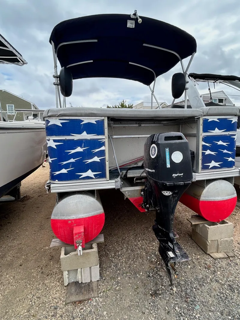 Slide: The Image of 2003 Starcraft 200 Fish Pontoon with blue star design, outboard motor, and canopy. - 16