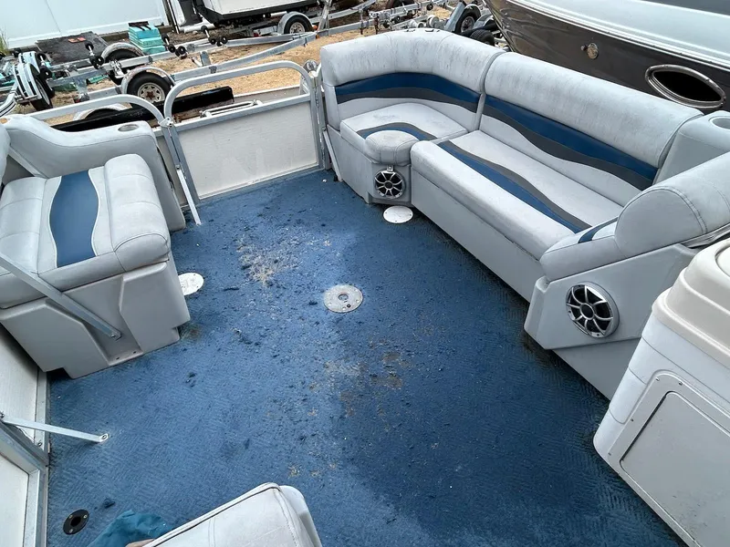 Slide: The Image of 2003 Starcraft 200 Fish Pontoon interior with blue carpet and gray seating. - 7