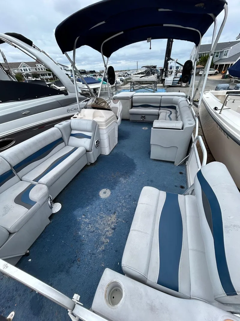 Slide: The Image of 2003 Starcraft 200 Fish Pontoon with blue and white seating, docked at a marina. - 8