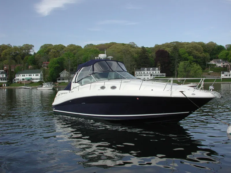 The Image of 2005 Sea Ray 340 Sundancer yacht on calm water, surrounded by lush greenery. - 0