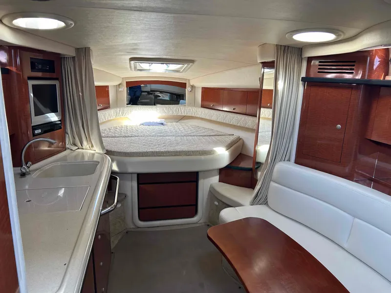 Slide: The Image of 2005 Sea Ray 340 Sundancer cabin interior with bed, kitchenette, and seating area. - 11