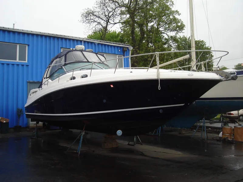 Slide: The Image of 2005 Sea Ray 340 Sundancer yacht on dry dock near blue building. - 2