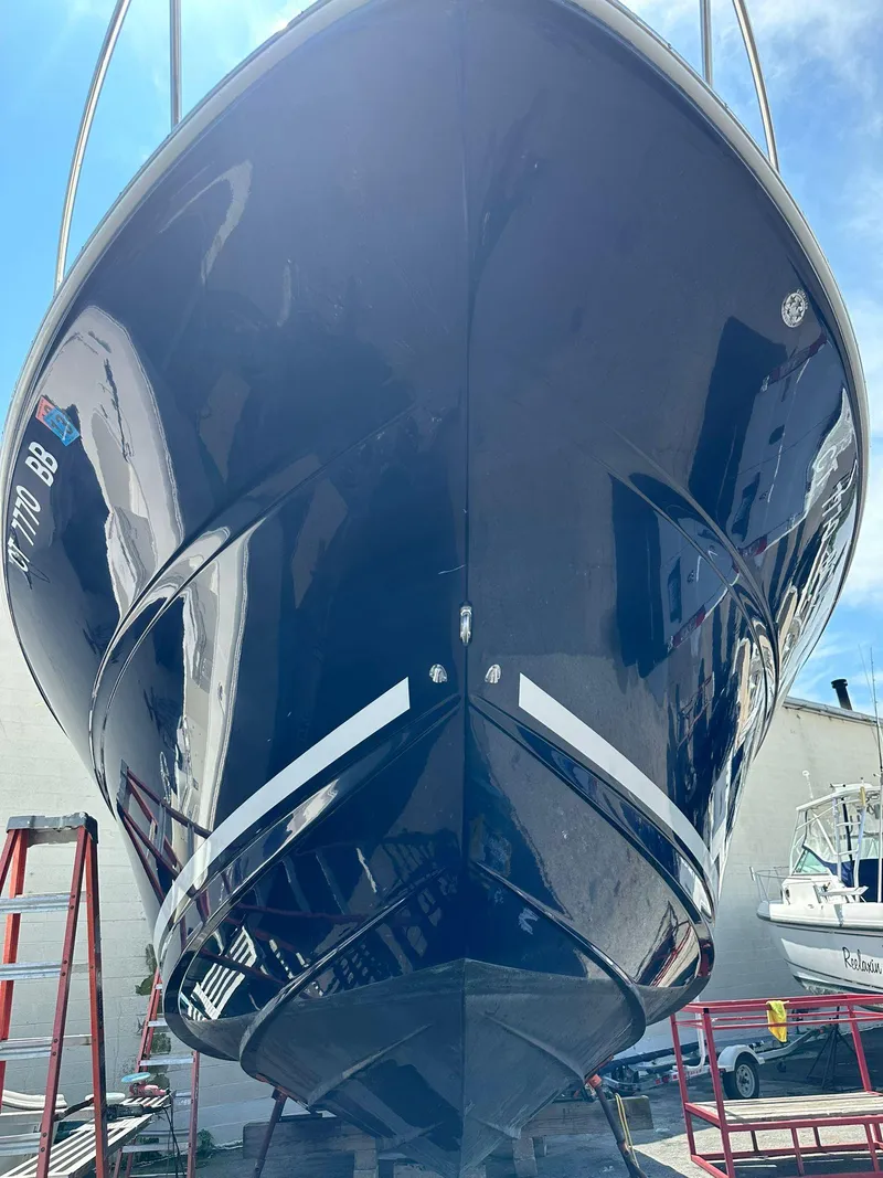 Slide: The Image of 2005 Sea Ray 340 Sundancer boat, sleek hull design, docked under clear sky. - 5