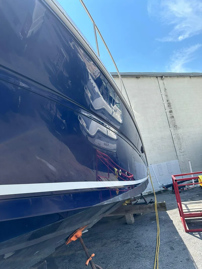 Slide: The Image of 2005 Sea Ray 340 Sundancer boat in dry dock, blue hull, sunny day. - 6