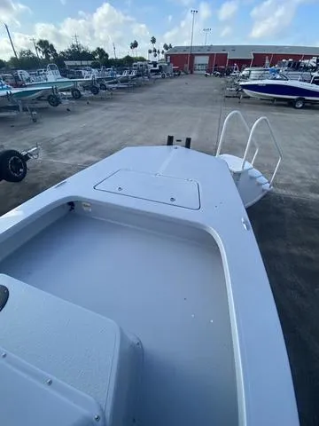 Slide: The Image of 2024 Majek M2 ILLUSION boat on display in a marina with trailers. - 10