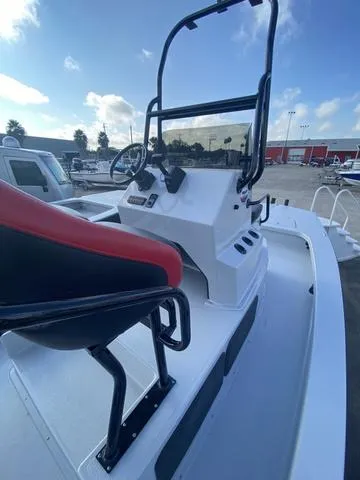 Slide: The Image of 2024 Majek M2 ILLUSION boat with red and black seating, docked under a blue sky. - 9