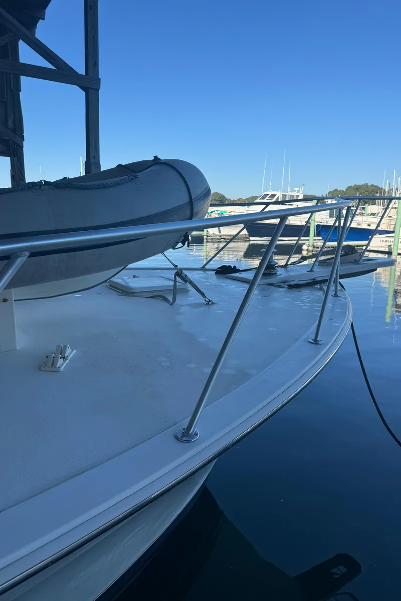 Slide: The Image of 1992 Post 46 Sportfish boat docked, featuring a sleek deck and railing. - 18