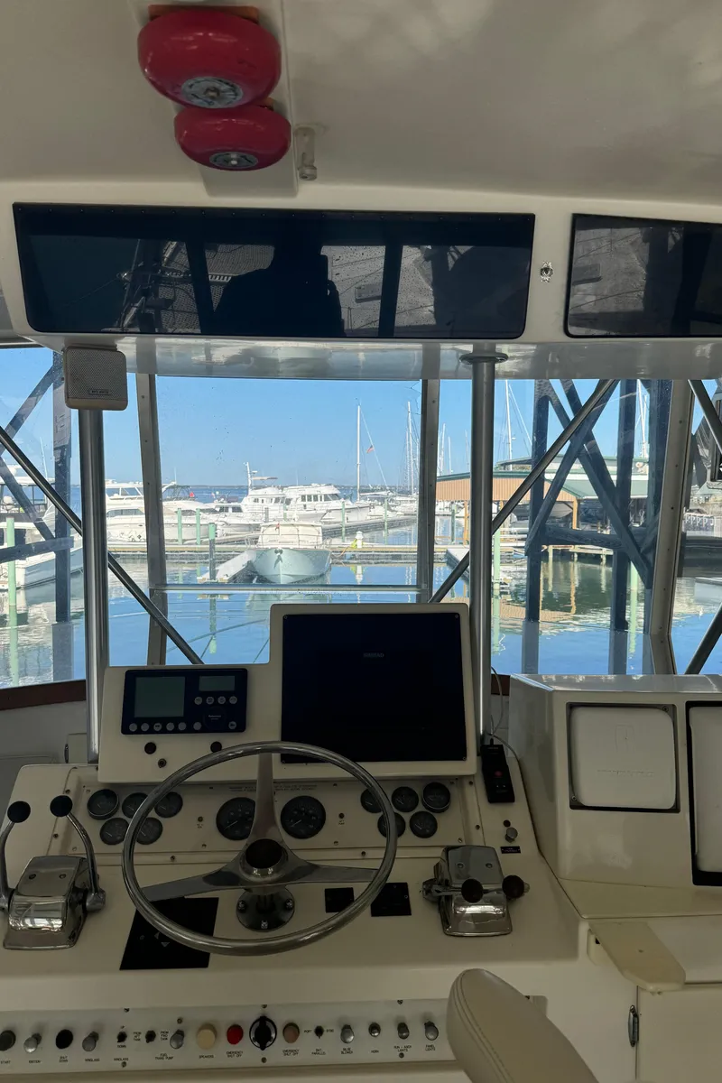 Slide: The Image of 1992 Post 46 Sportfish helm with marina view, featuring steering wheel and control panels. - 20