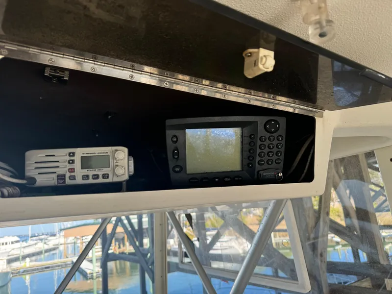 Slide: The Image of 1992 Post 46 Sportfish boat electronics, featuring a navigation system and radio, dockside view. - 27