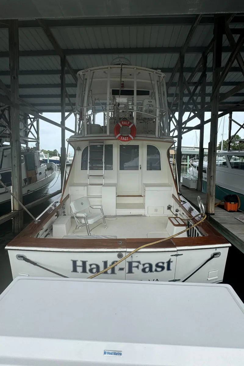 Slide: The Image of 1992 Post 46 Sportfish boat docked, rear view, under a covered marina. - 2