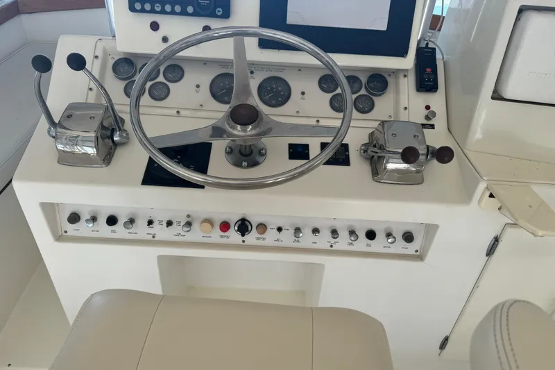 Slide: The Image of 1992 Post 46 Sportfish helm with steering wheel, controls, and instrument panel. - 22