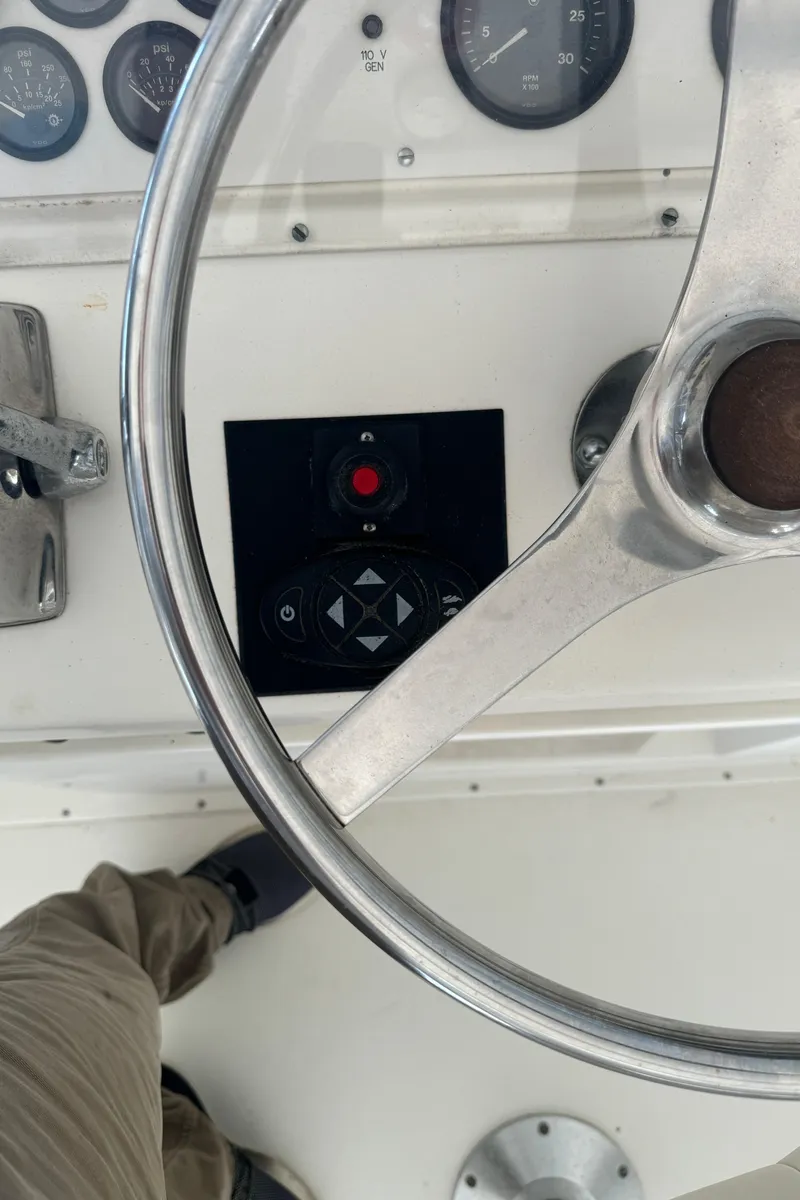 Slide: The Image of Steering wheel and controls of a 1992 Post 46 Sportfish boat. - 23