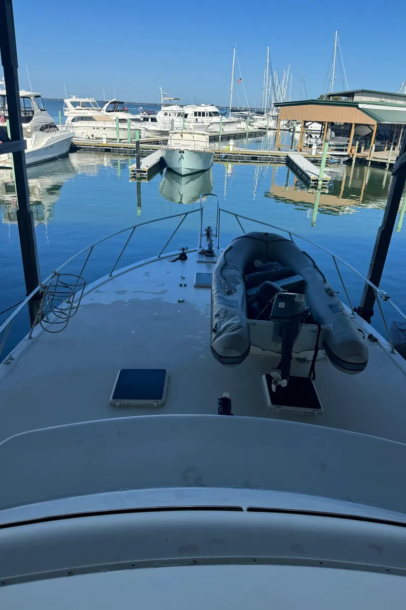 Slide: The Image of 1992 Post 46 Sportfish boat docked at marina with inflatable dinghy on deck. - 32