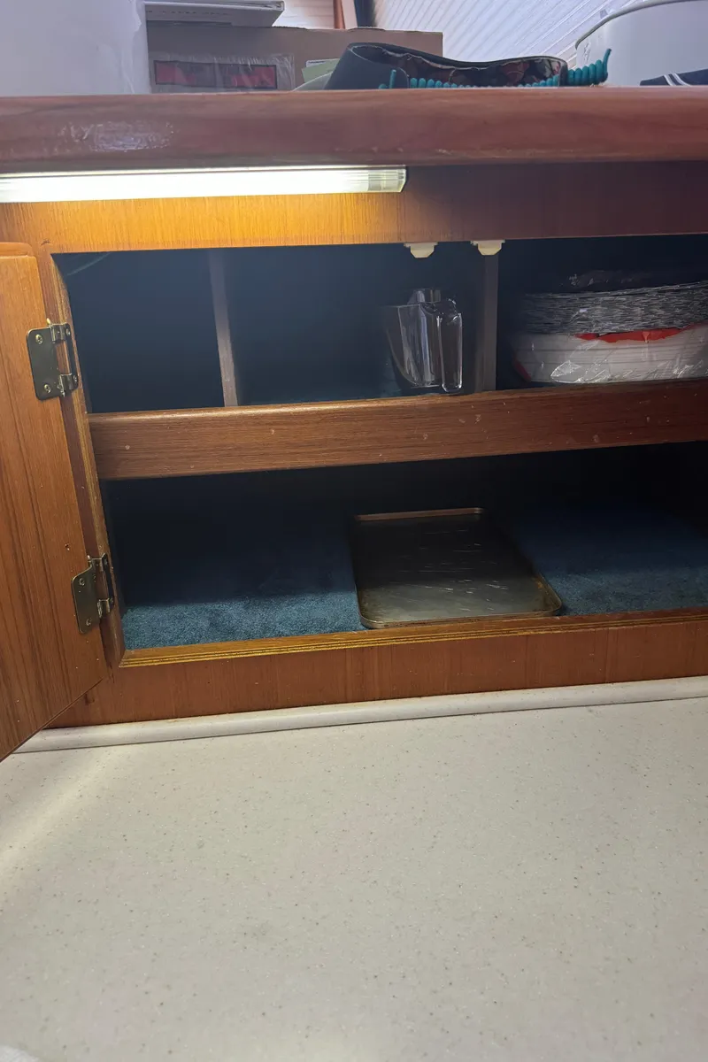 Slide: The Image of Wooden cabinet interior on a 1992 Post 46 Sportfish boat, with shelves and stored items. - 49