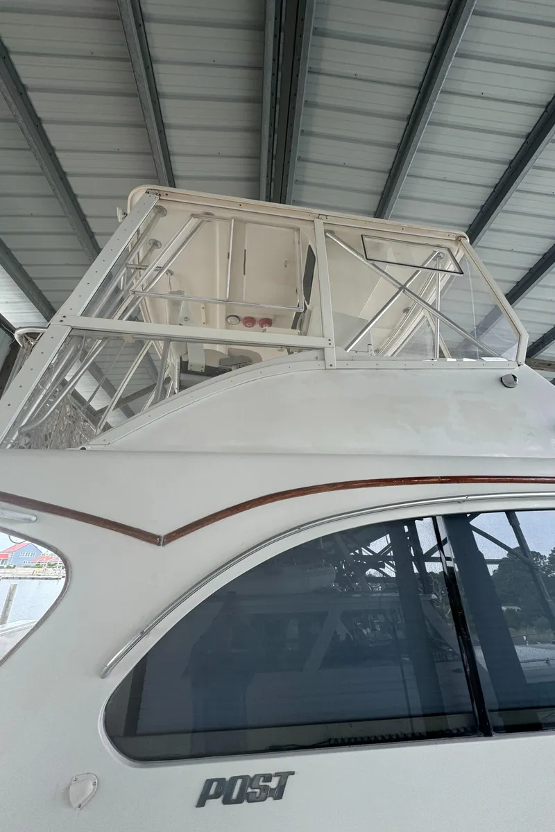 Slide: The Image of 1992 Post 46 Sportfish boat under a metal roof, showcasing its upper deck and sleek design. - 6