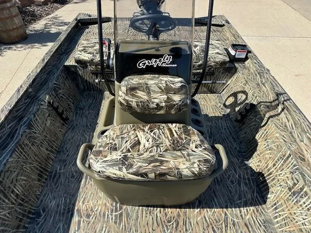 Slide: The Image of 2025 Tracker Grizzly 1860 CC boat with camouflage seating and steering console. - 7