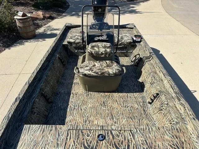 Slide: The Image of 2025 Tracker Grizzly 1860 CC boat with camouflage design, featuring central seating and console. - 8