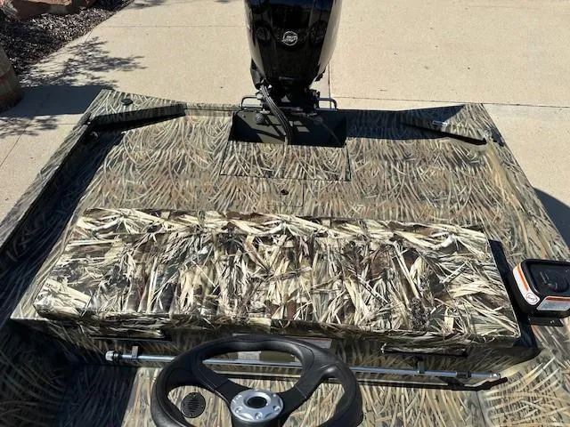 Slide: The Image of 2025 Tracker Grizzly 1860 CC boat with camouflage seating and steering wheel. - 9