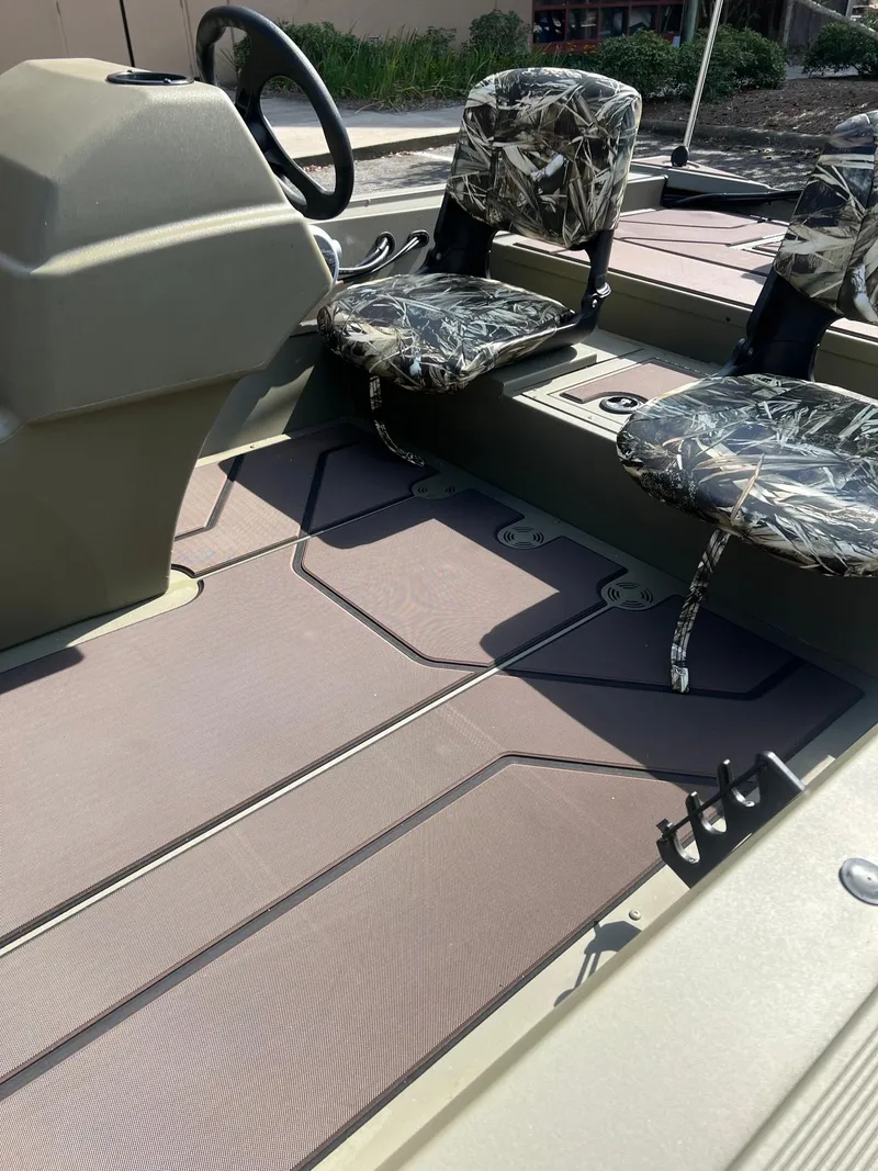 Slide: The Image of 2025 Tracker Grizzly 1754 SC boat interior with camo seats and steering console. - 10