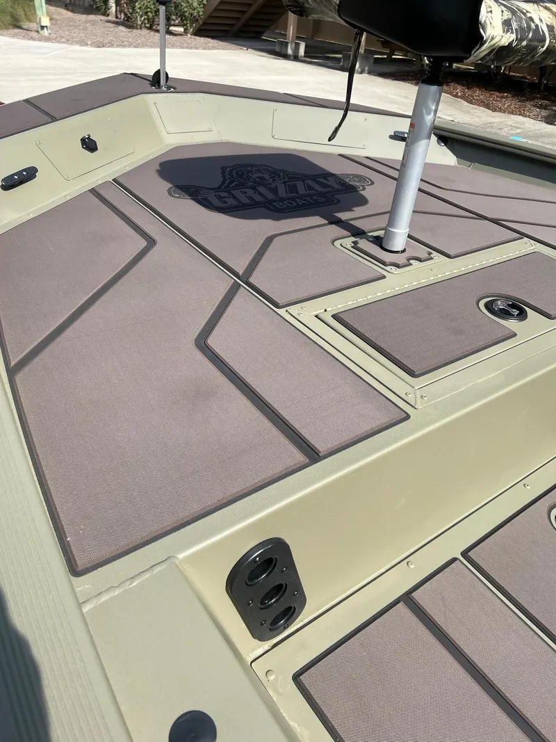 Slide: The Image of 2025 Tracker Grizzly 1754 SC boat deck with storage compartments and seating. - 12