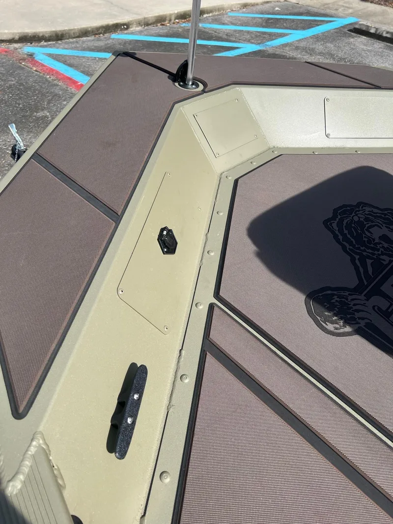 Slide: The Image of 2025 Tracker Grizzly 1754 SC boat deck with storage compartments and cleats. - 13