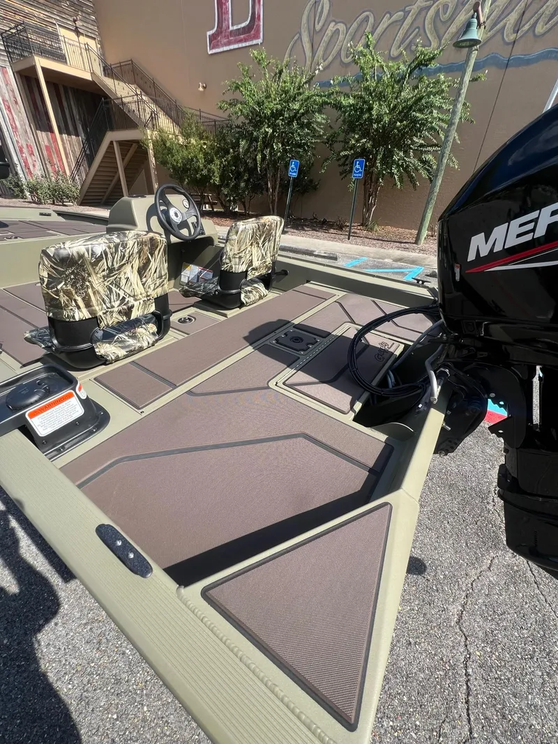 Slide: The Image of 2025 Tracker Grizzly 1754 SC boat with camo seats and Mercury engine. - 7