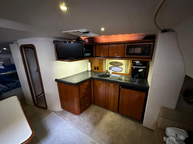 Slide: The Image of Interior of 2000 Carver 400 Express Yacht kitchen with wood cabinets and modern appliances. - 15