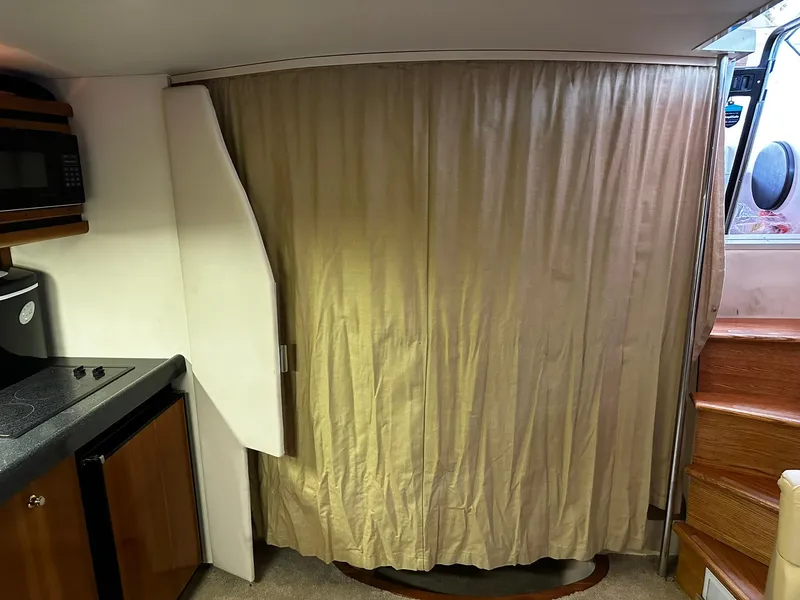 Slide: The Image of Interior of 2000 Carver 400 Express Yacht with curtain and kitchenette. - 17