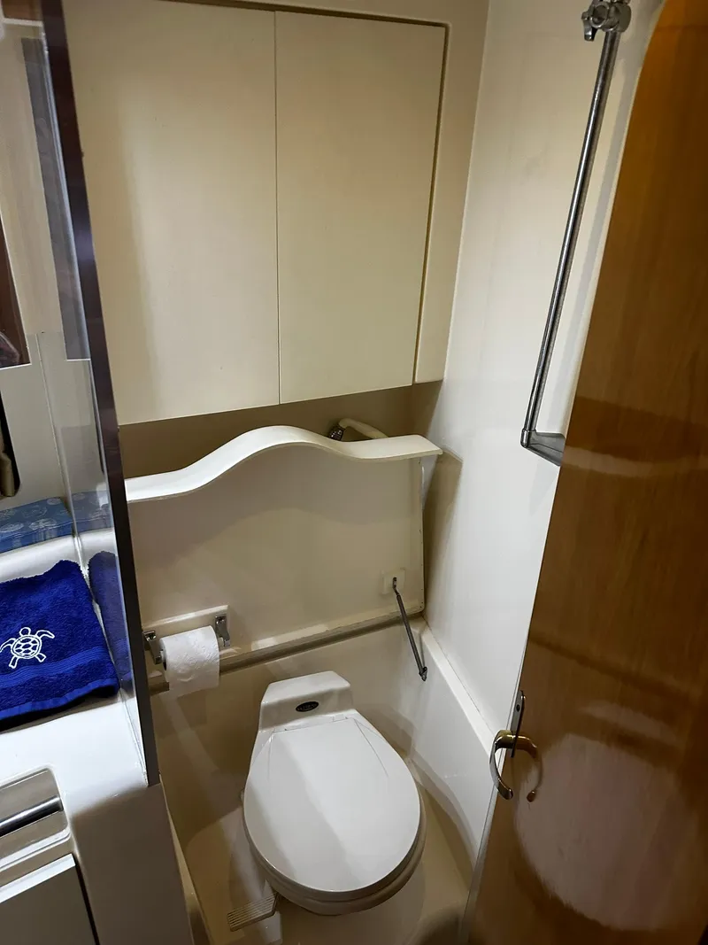 Slide: The Image of Bathroom interior of 2000 Carver 400 Express Yacht, featuring toilet and shower. - 21
