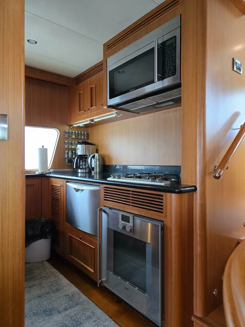 Slide: The Image of 2010 Ocean Alexander Classico yacht kitchen with modern appliances and wooden cabinetry. - 12