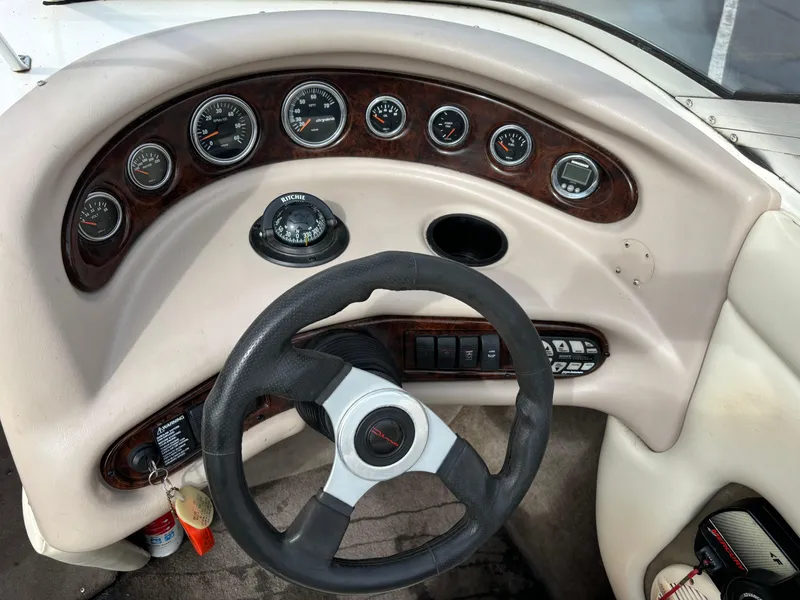 Slide: The Image of 2002 Bryant 214 boat dashboard with steering wheel and gauges. - 6