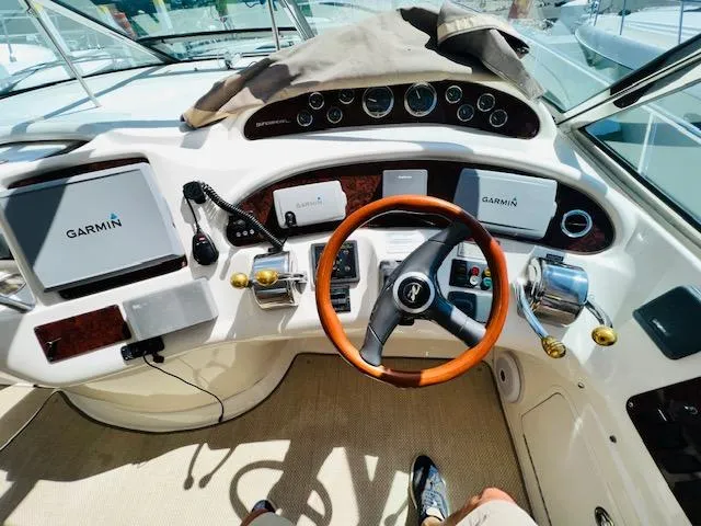 Slide: The Image of 1999 Sea Ray 460 Sundancer helm with Garmin navigation systems and wooden steering wheel. - 11