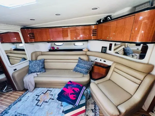 Slide: The Image of Interior of 1999 Sea Ray 460 Sundancer yacht with leather seating and wooden cabinets. - 16