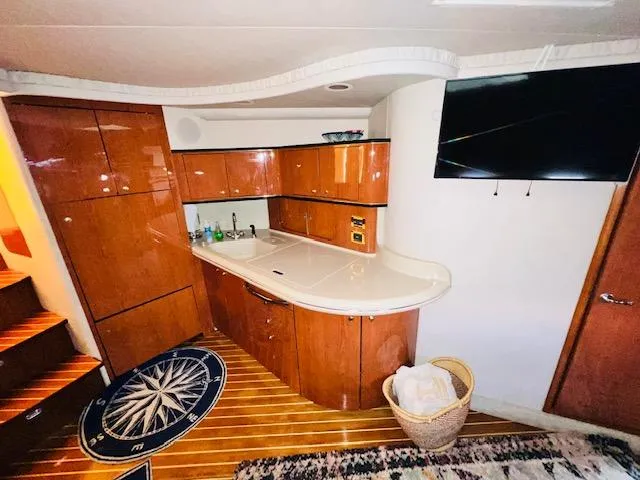 Slide: The Image of Interior of 1999 Sea Ray 460 Sundancer yacht with wooden cabinetry and modern amenities. - 17