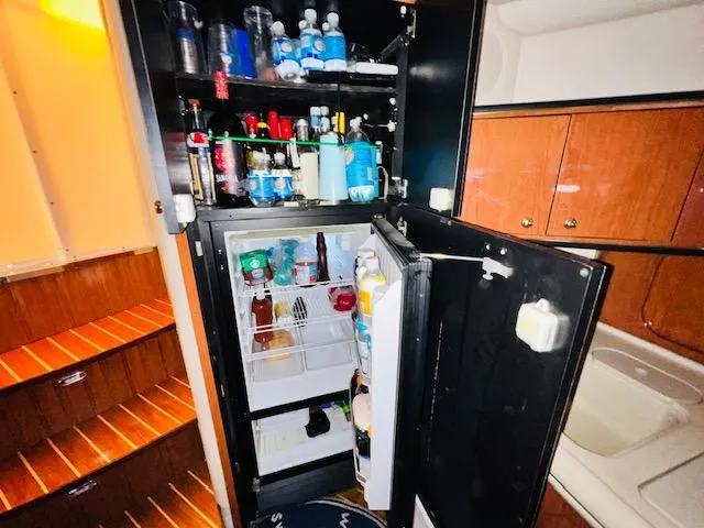 Slide: The Image of Open refrigerator in 1999 Sea Ray 460 Sundancer yacht, stocked with beverages and condiments. - 18