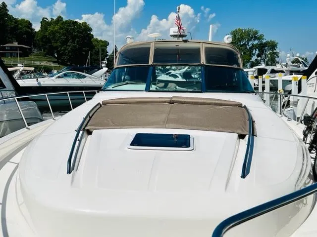 Slide: The Image of 1999 Sea Ray 460 Sundancer yacht docked at marina under clear blue sky. - 2